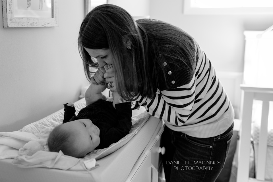 mom kissing baby's feet on changing table