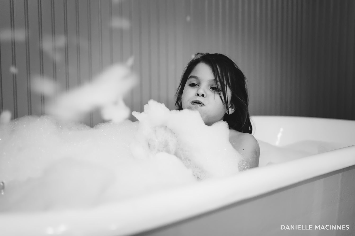 Girl blowing bubbles in bath