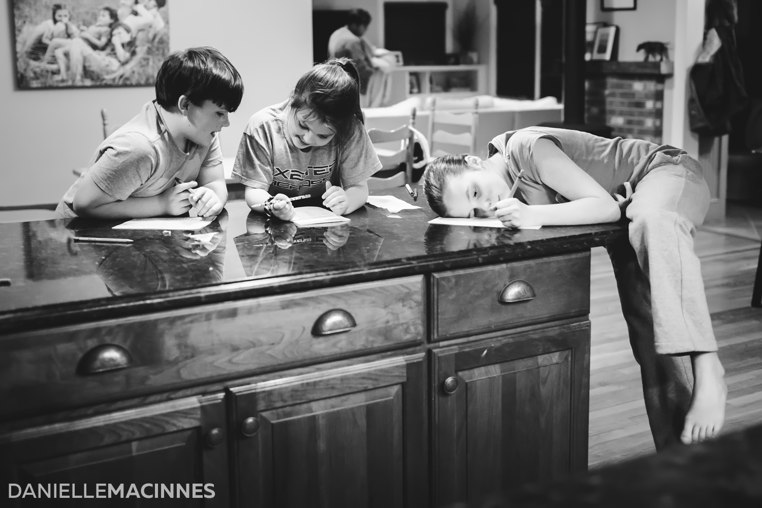 three kids at counter writing