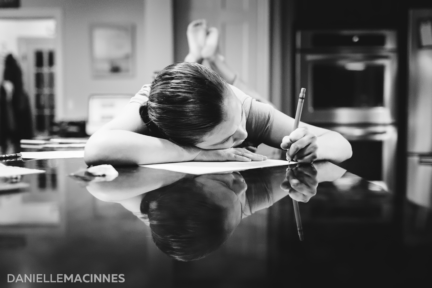girl laying on counter writing with reflection