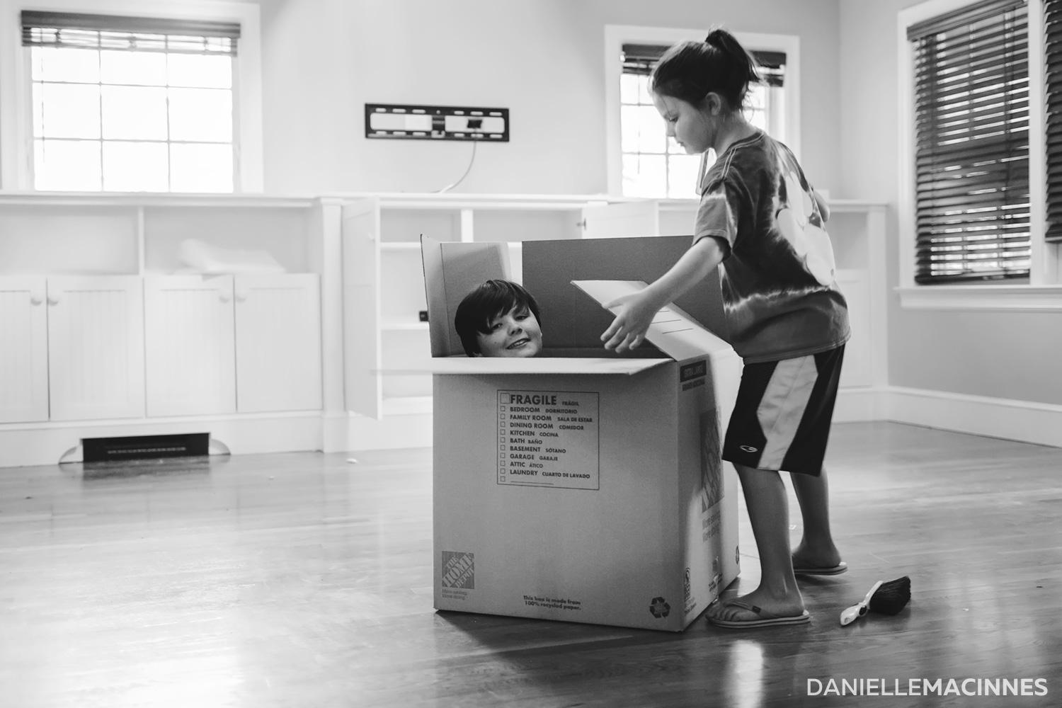 little boy in box and girl trying to close it