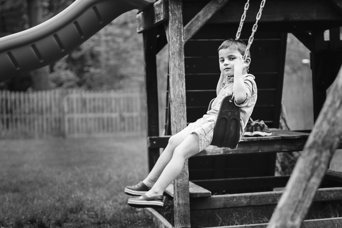 Little boy on swing looking at camera