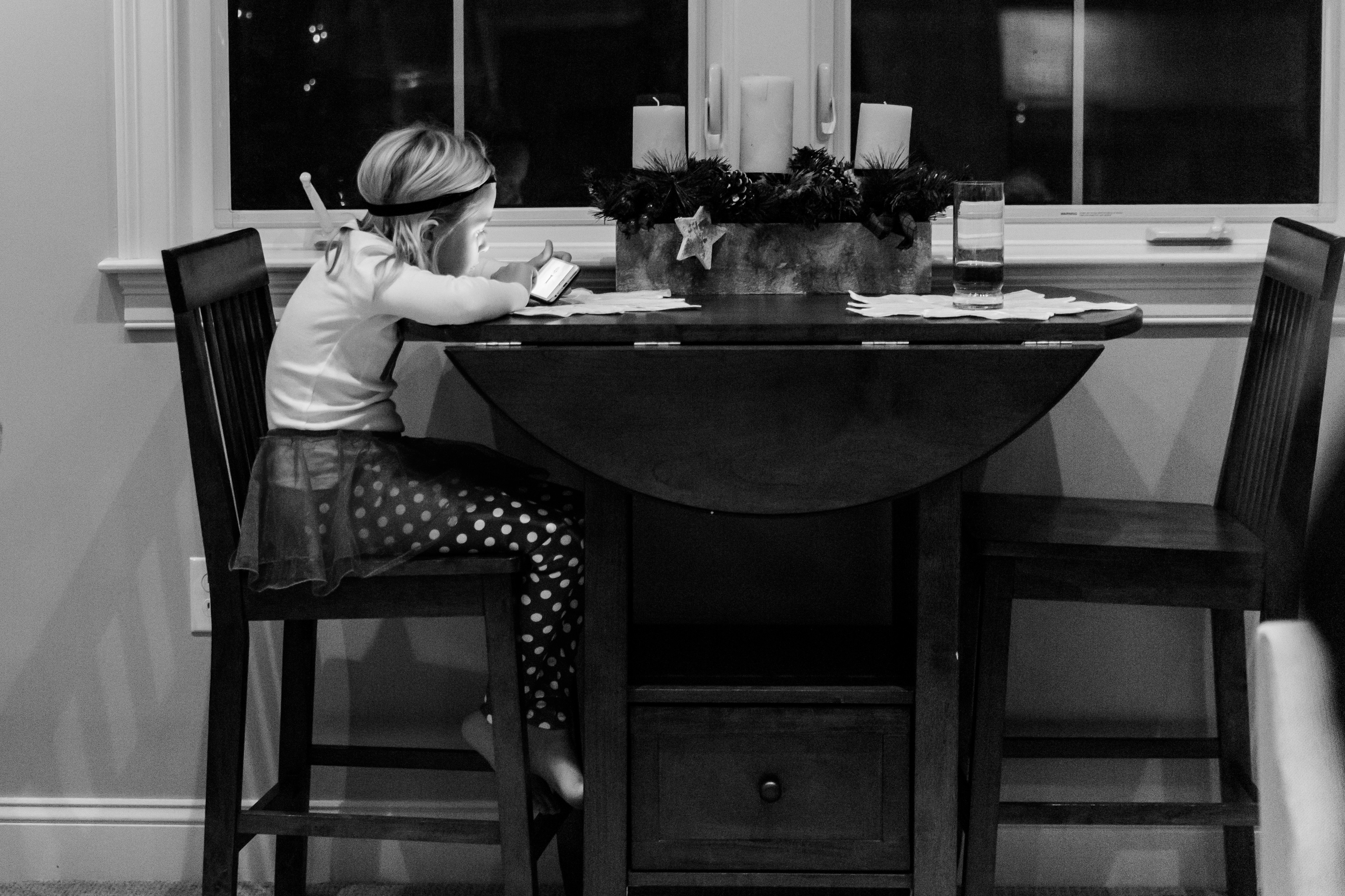 girl at table using iphone
