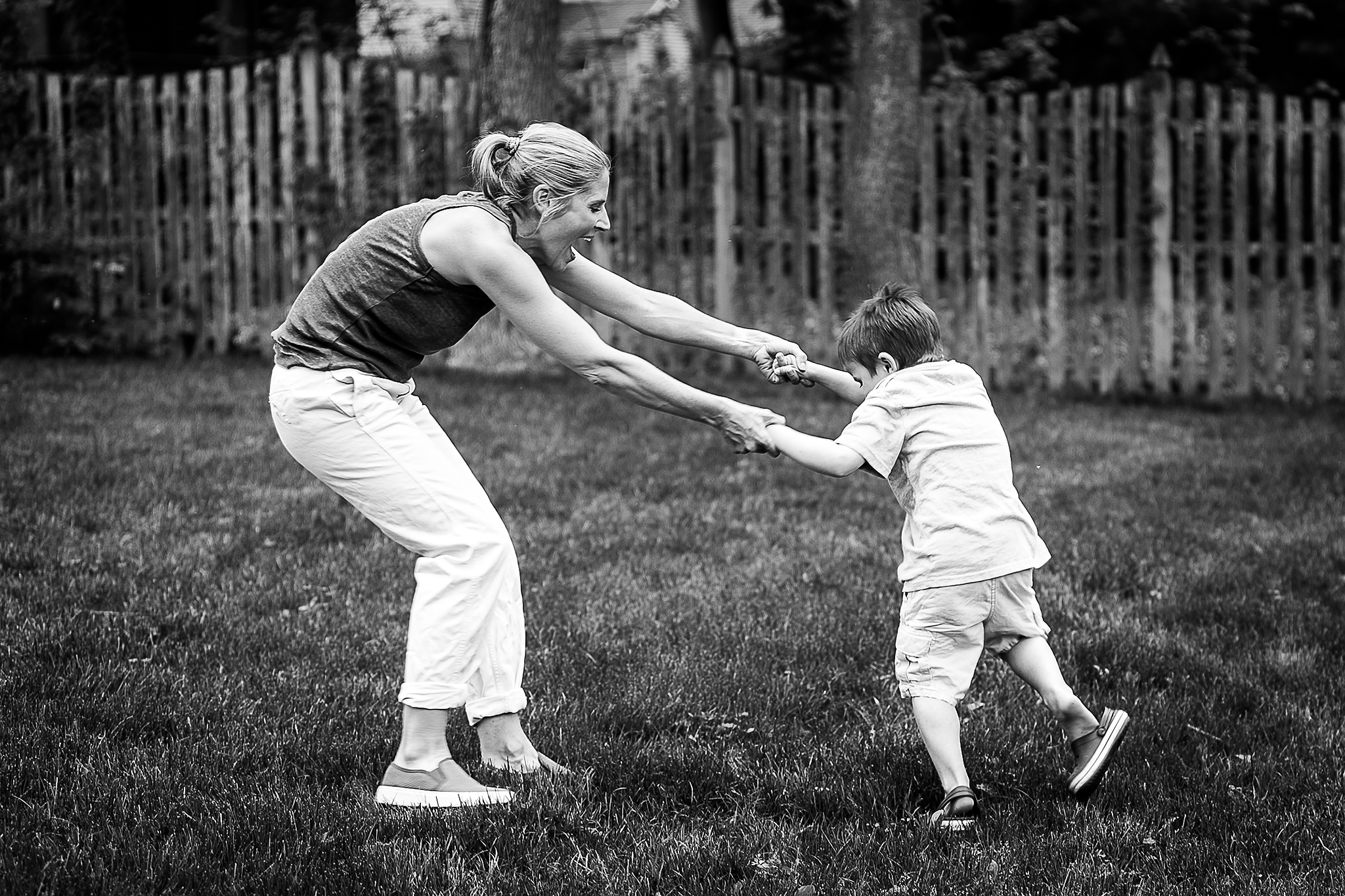 mom laughing and dancing with son in yard