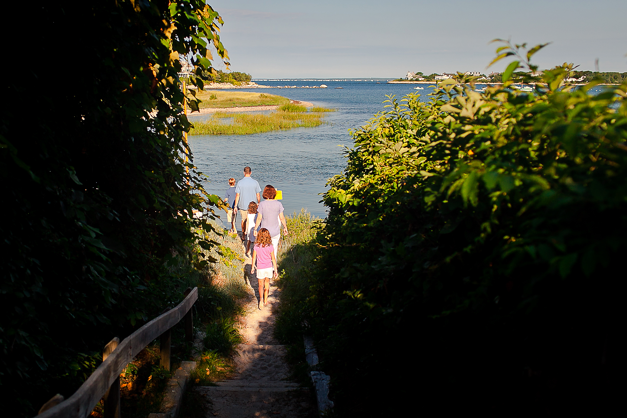 family walking down path to beach