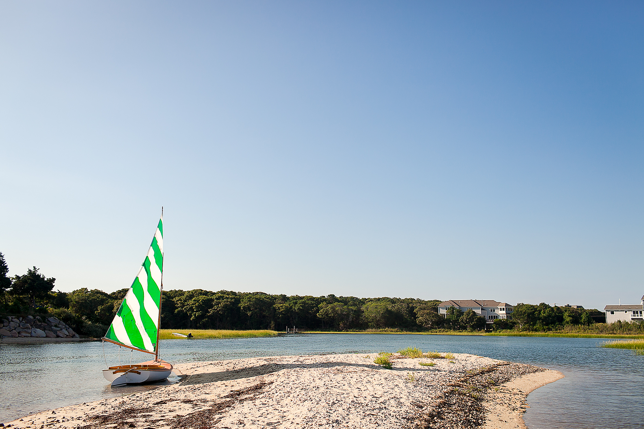 Sailboat on shore with green and white sale