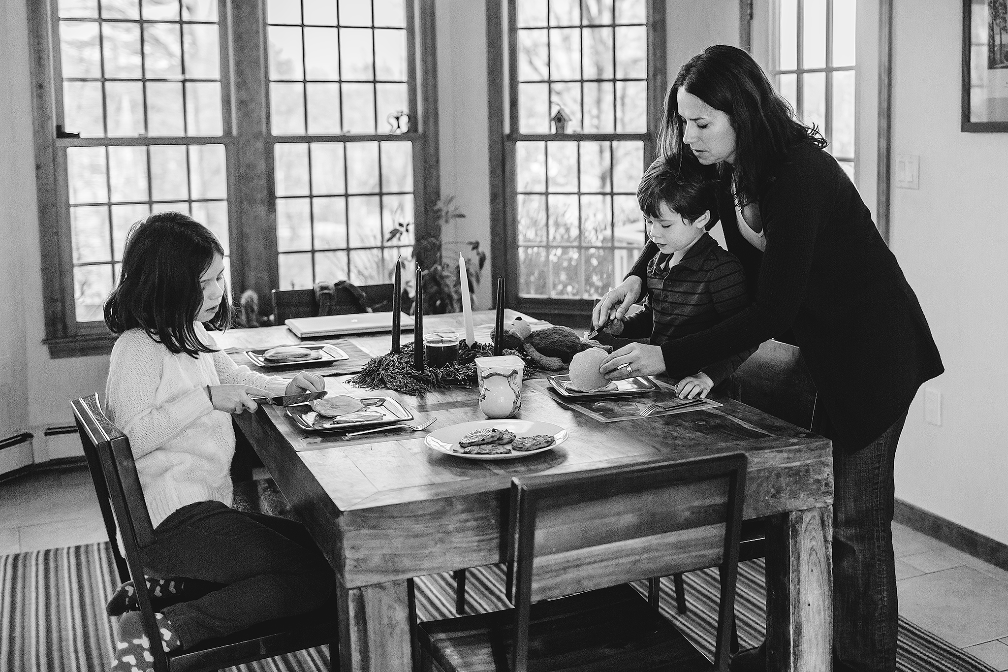 mom helping little boy cut pancakes