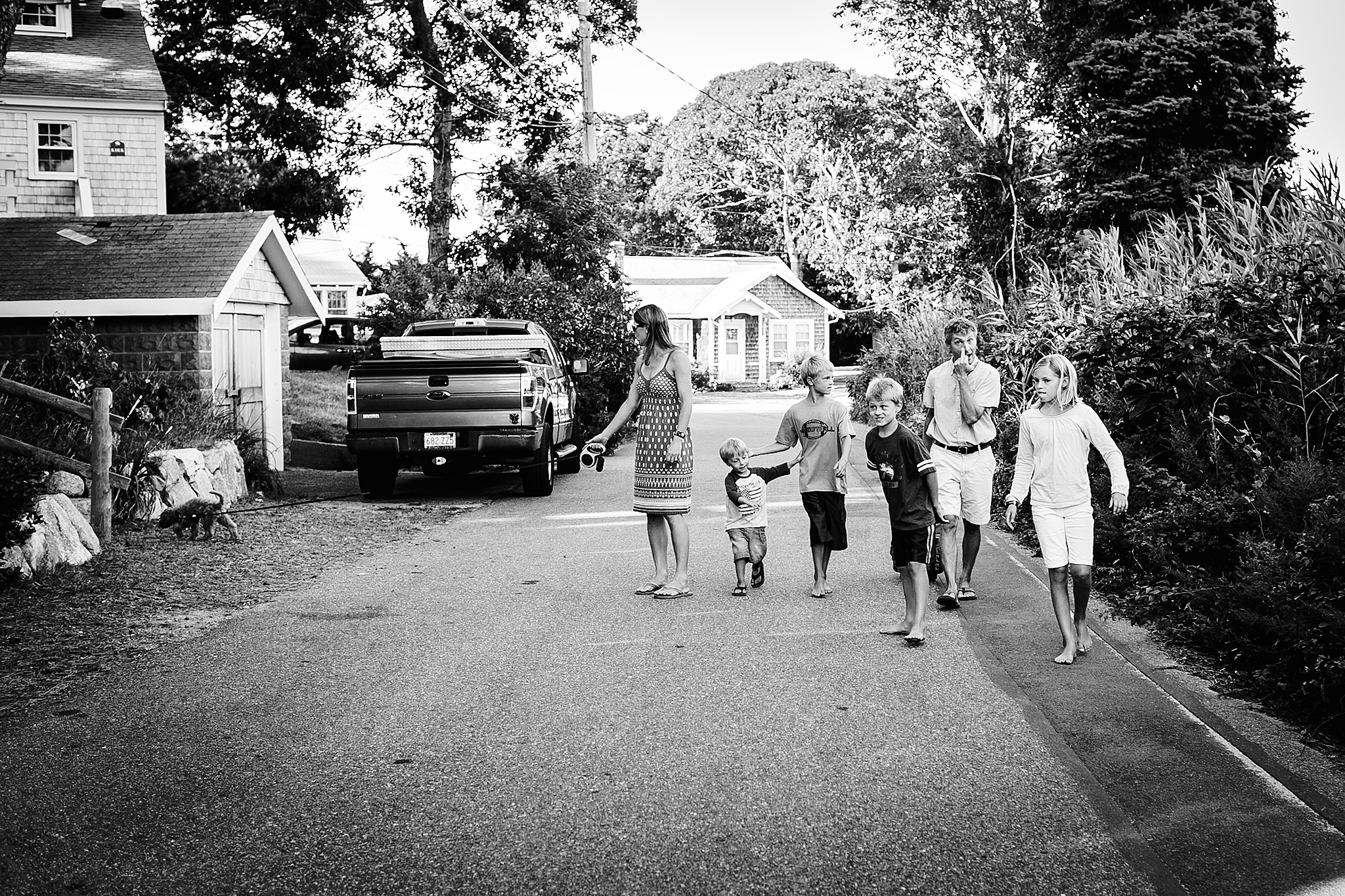 family walking down street black and white