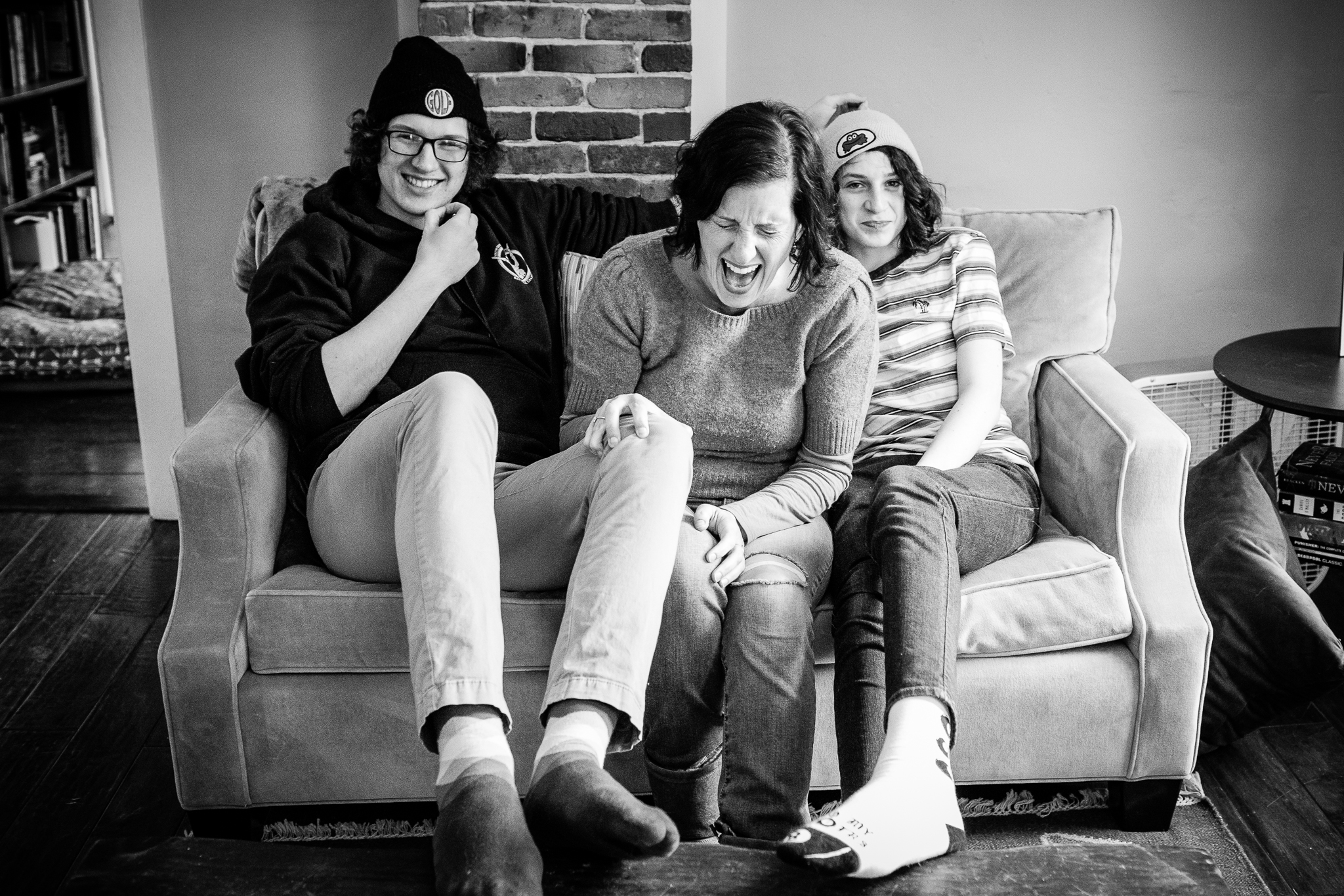 mom sitting between two teenage sons laughing