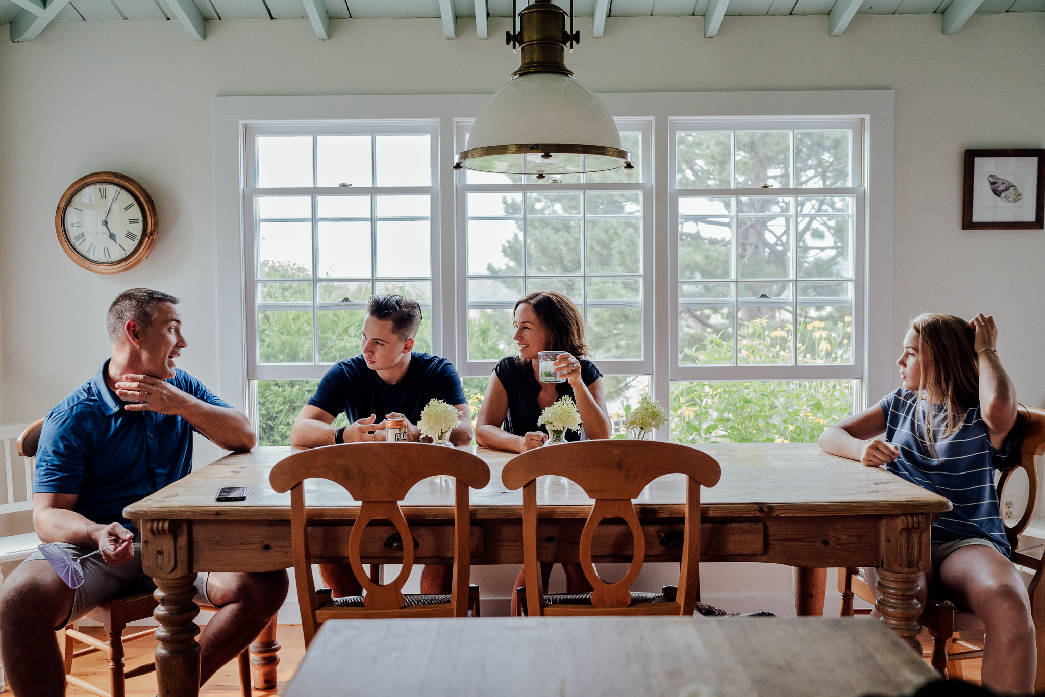 mom, dad sitting at kitchen table with teenage son and daughter
