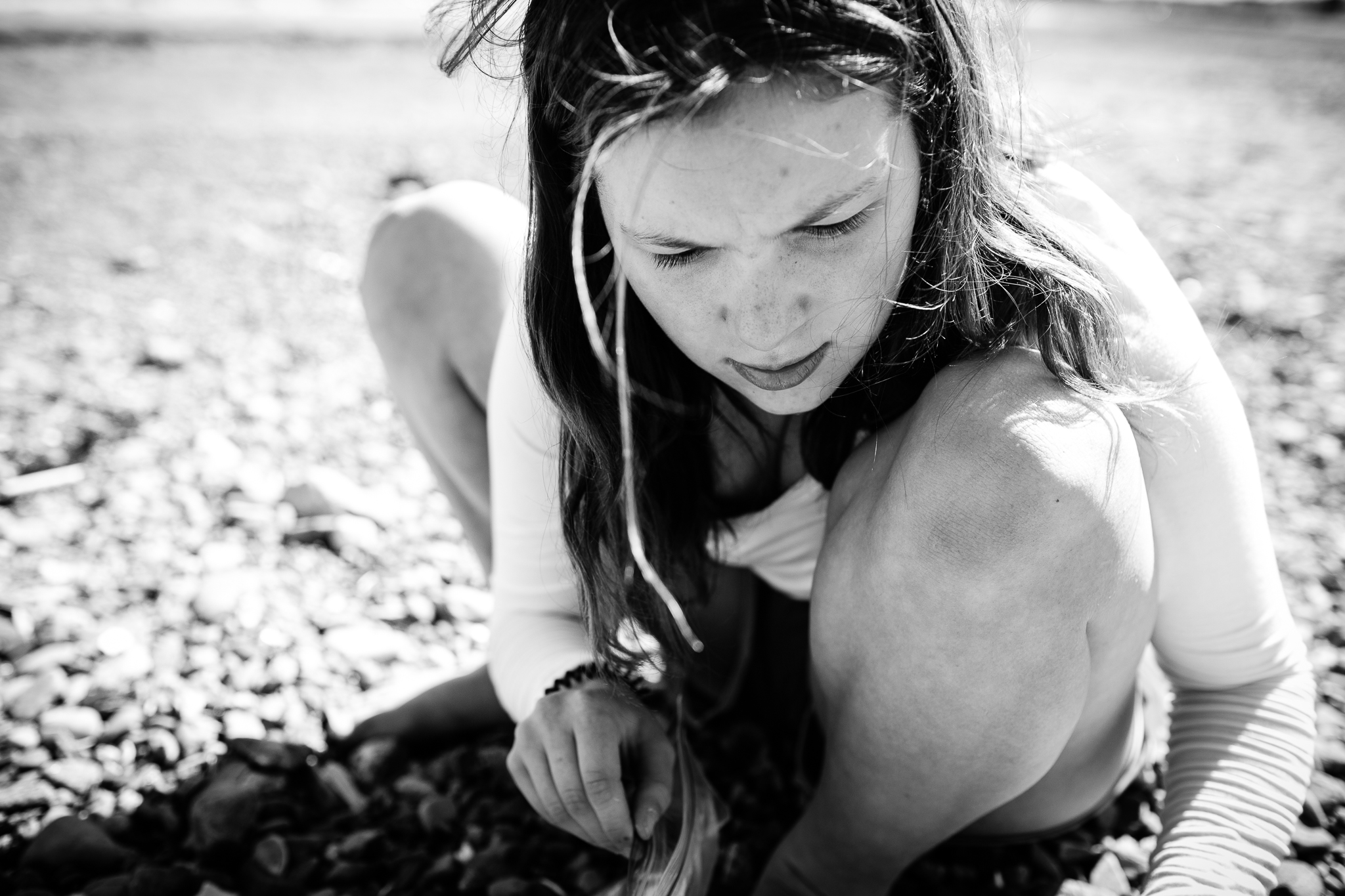 close up of teenage girl squatting on beach