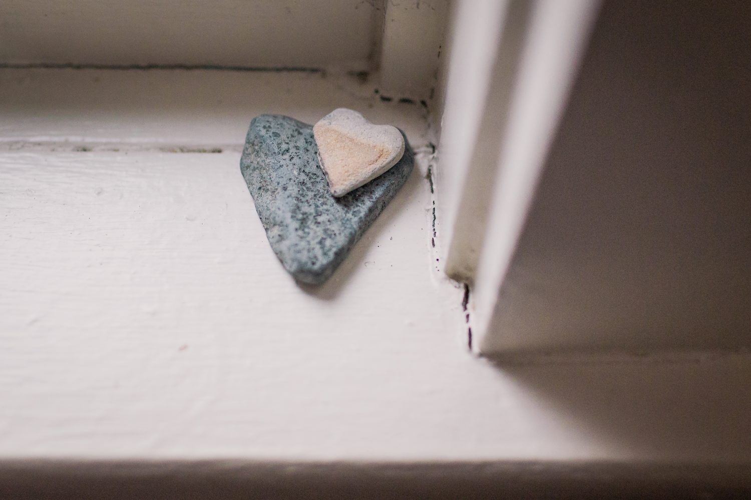 two heart shaped rocks on a window sill