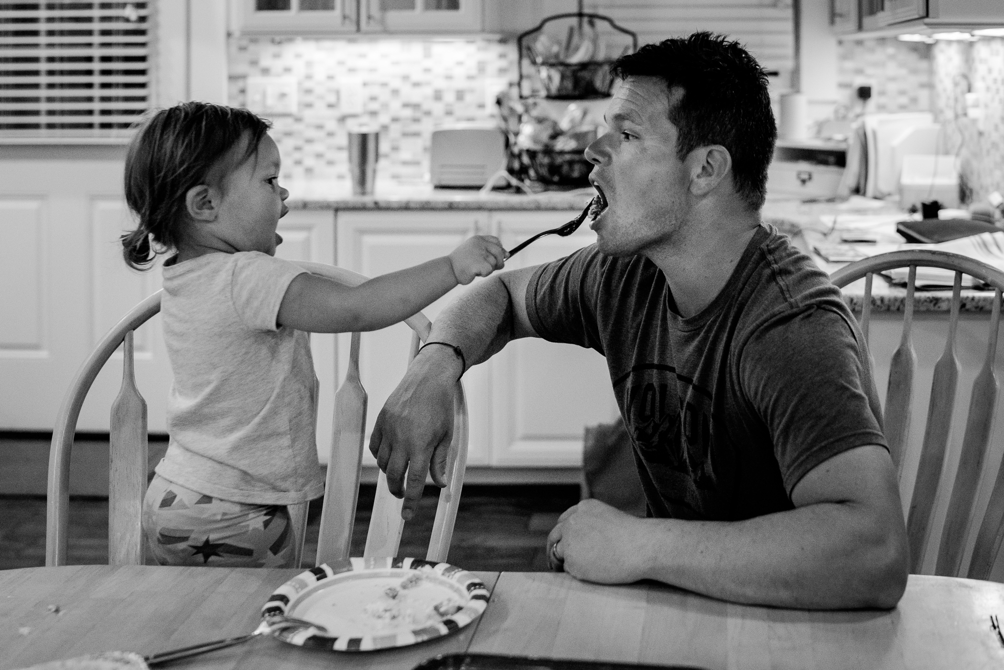 little girl feeding her father with a fork