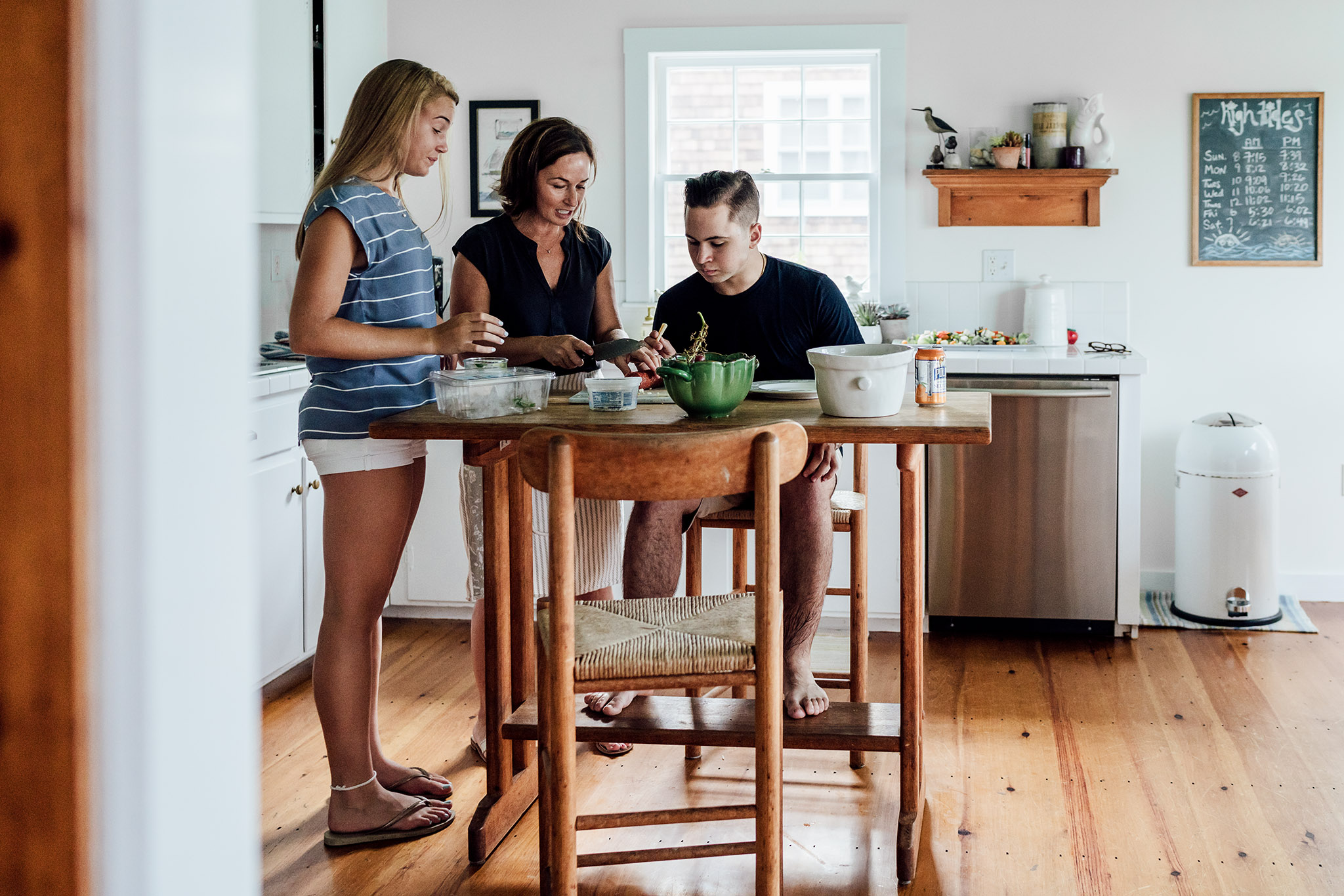 mom with teenage son and daughter prepping food in the kitchen